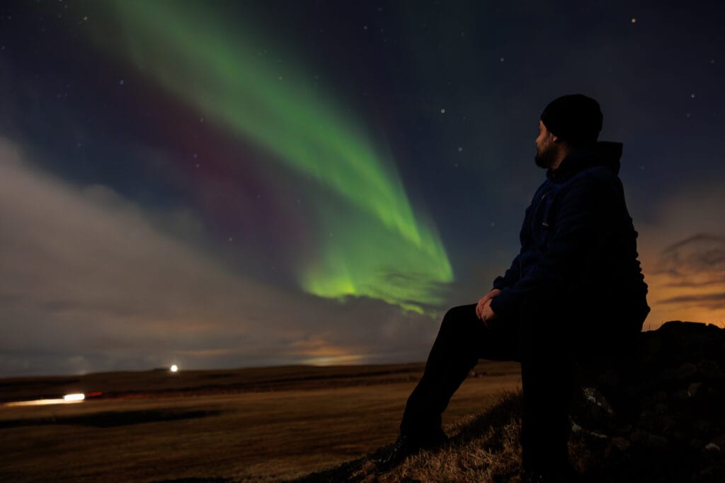 viajante-apreciando-as-luzes-norte-1024x683 Guia Completo da Aurora Boreal: Onde, Quando e Como Ver as Luzes do Norte